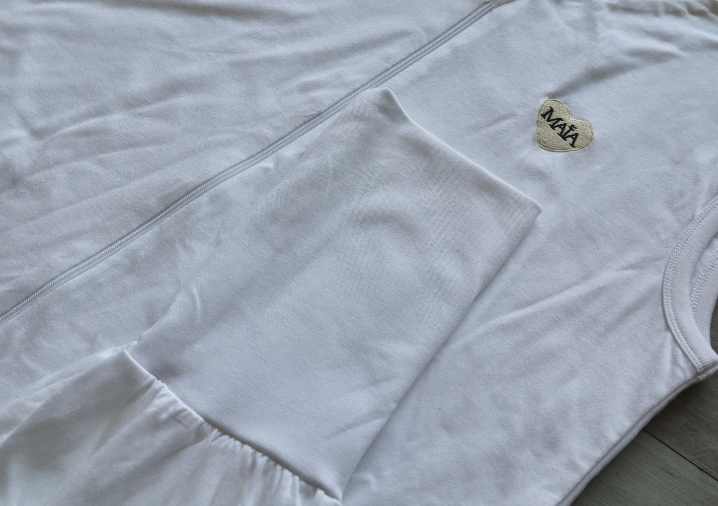 Détail cheville gigoteuse adulte MAÏA TOG 1 blanche avec logo brodé, finition soignée
