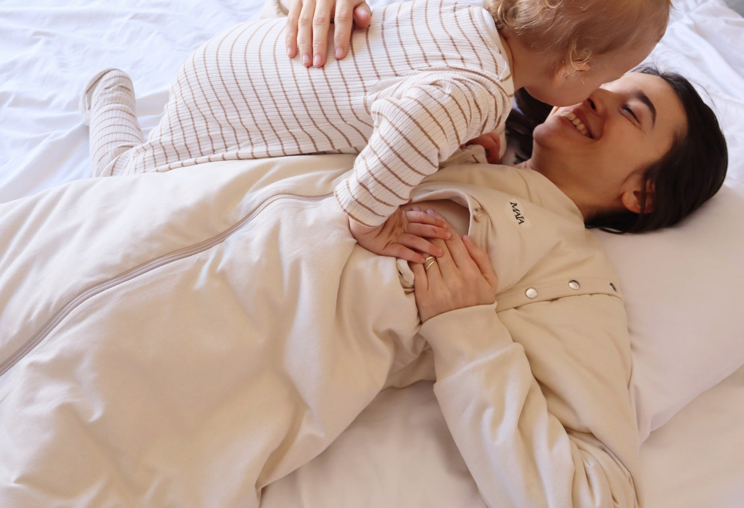 Maman allaitant bébé avec gigoteuse adulte d'allaitement MAÏA TOG 2.5 beige, ouvertures latérales
