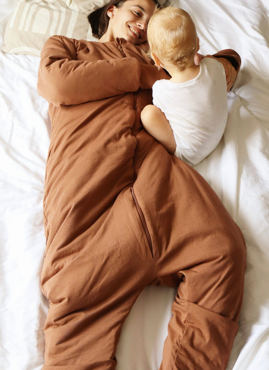 Maman avec bébé portant gigoteuse adulte MAÏA TOG 3.5 marron pour nuits froides d'hiver
